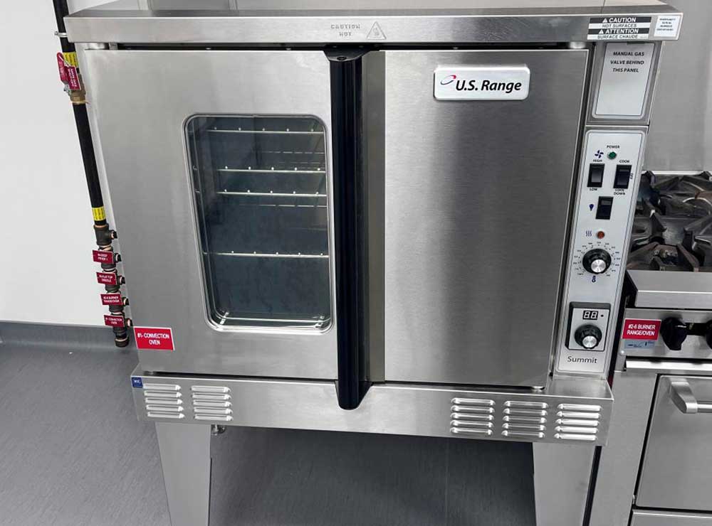 Technician cleaning commercial convection oven interior